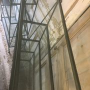 Pair of wrought iron and glass bookshelf shelves.