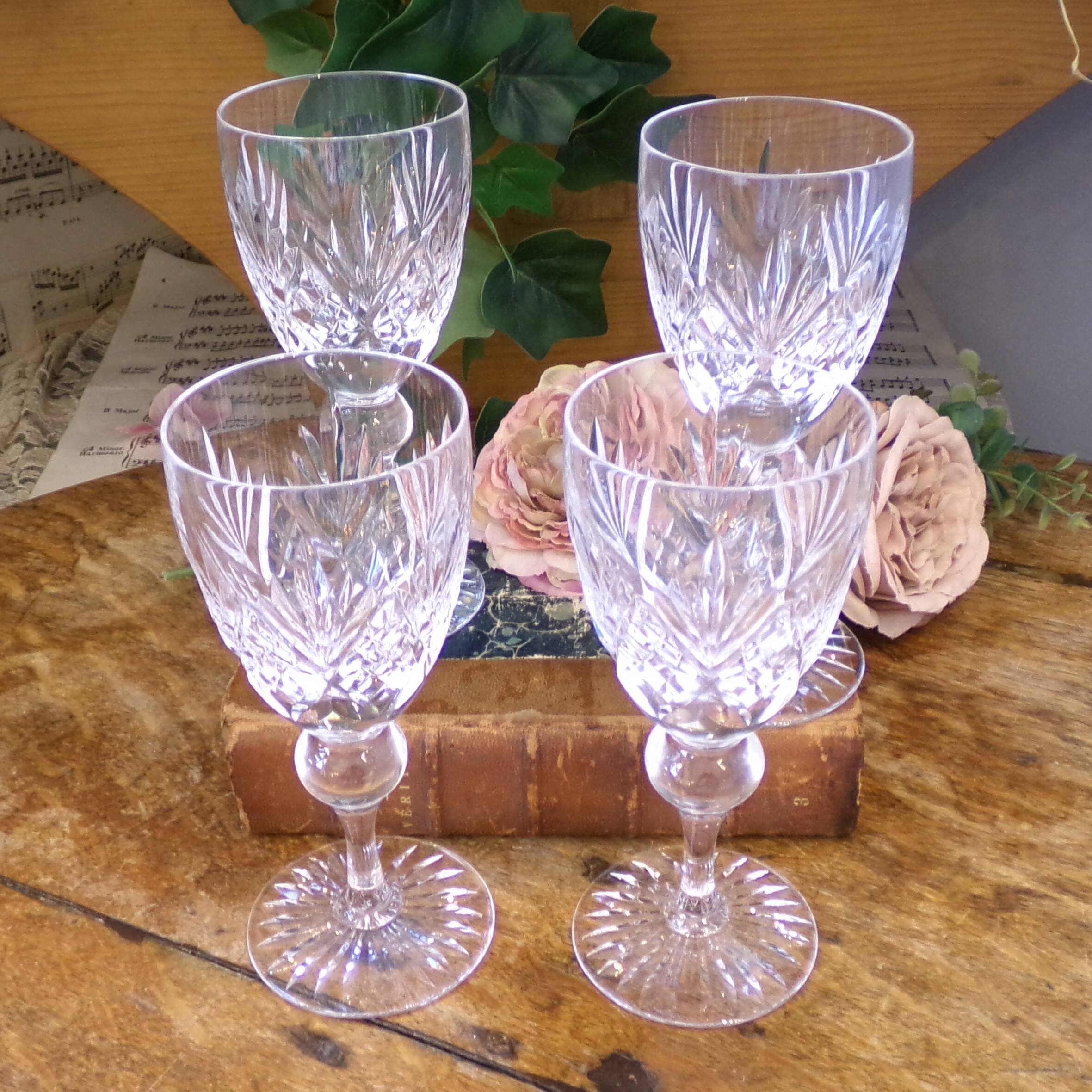 Cut crystal white wine glasses with a slender baluster-shaped stem.