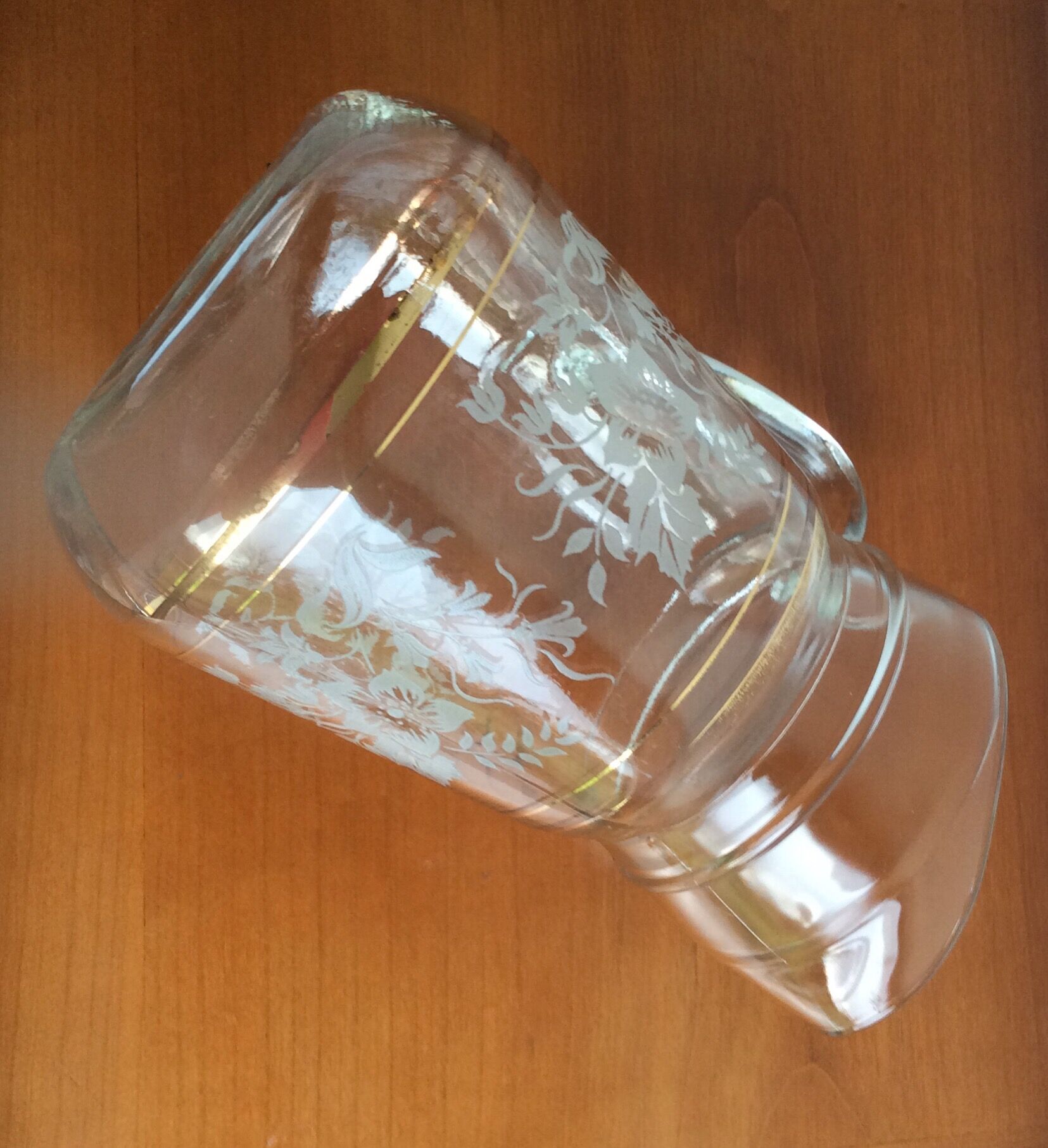 Old glass water pitcher with white flowers in relief with gold edging