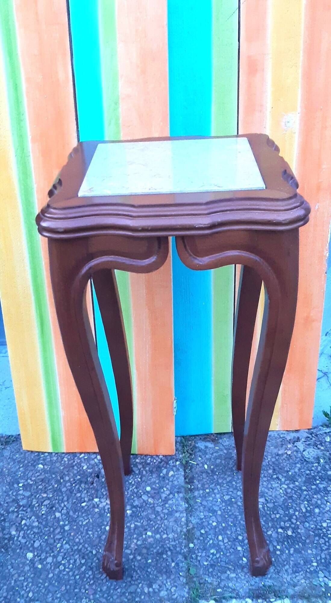 Curved leg wooden stand with a marble top.