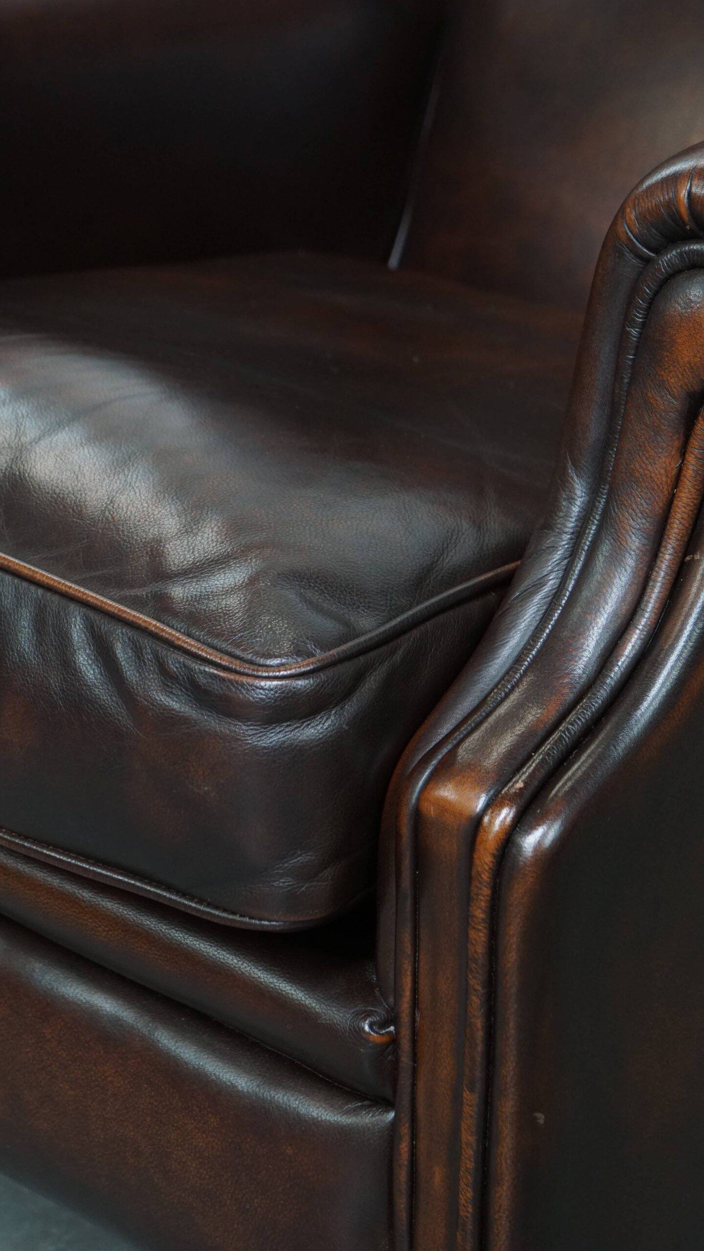 Comfortable wingback chair in English style made of cowhide leather