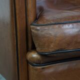 Unique vintage cognac-coloured leather club armchair with black piping