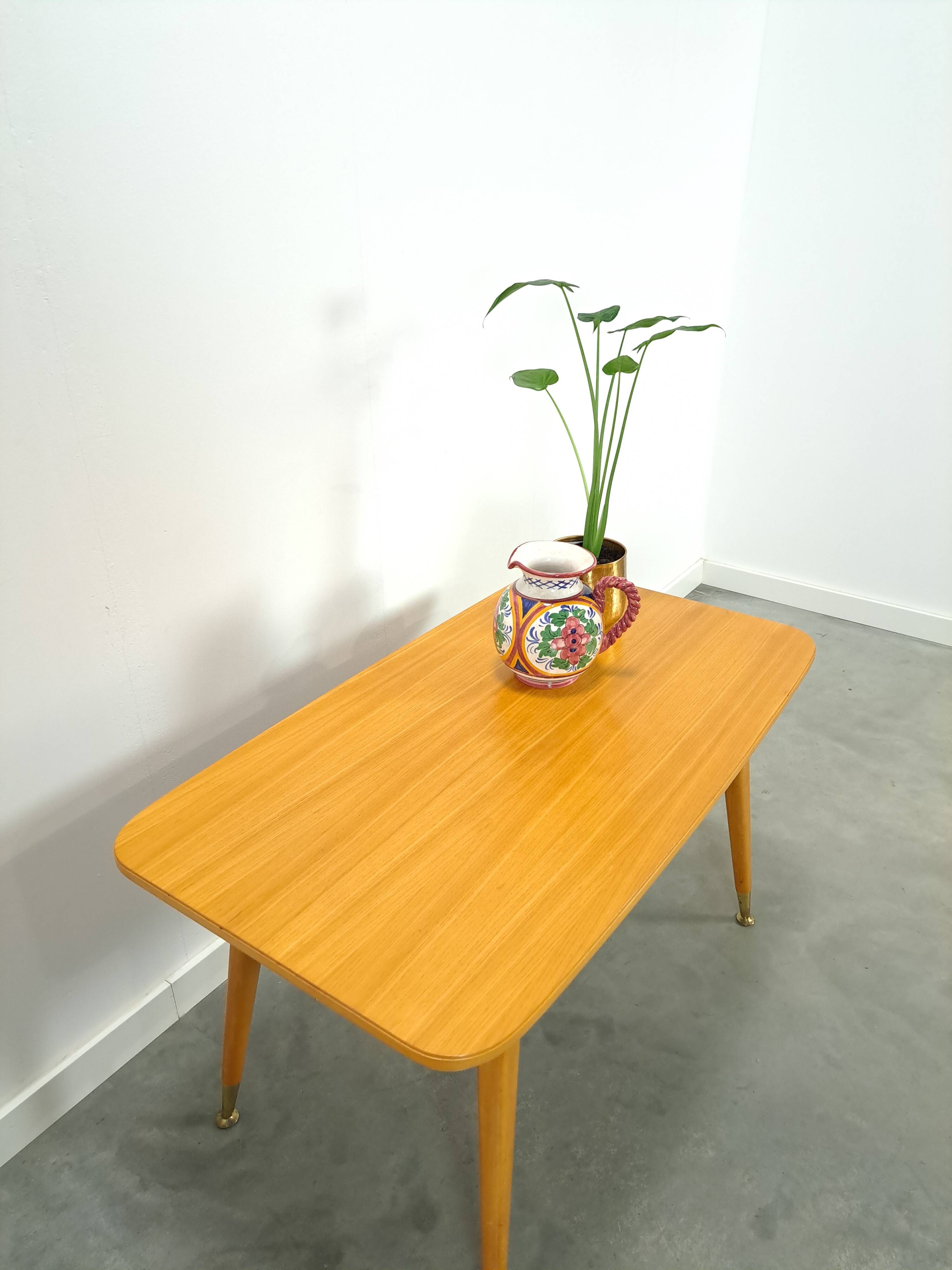 Vintage veneer table with pretty angular legs and brass at the base of the legs.
