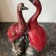 Pair of ceramic red glazed wading bird (crane) figurines.