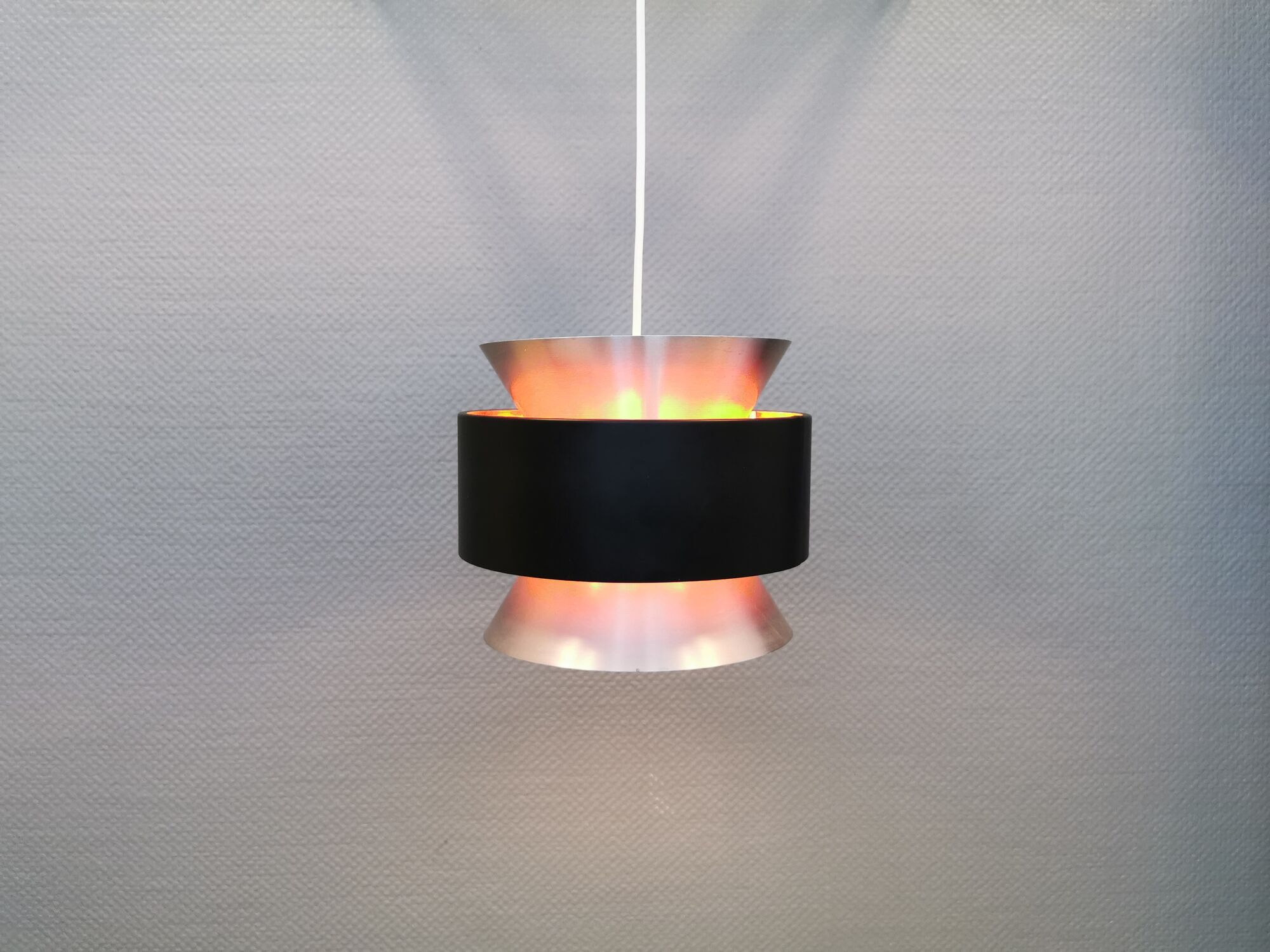 Hanging lamp,  of silver coloured aluminium with black "ring" and orange inner contrast lacquer.