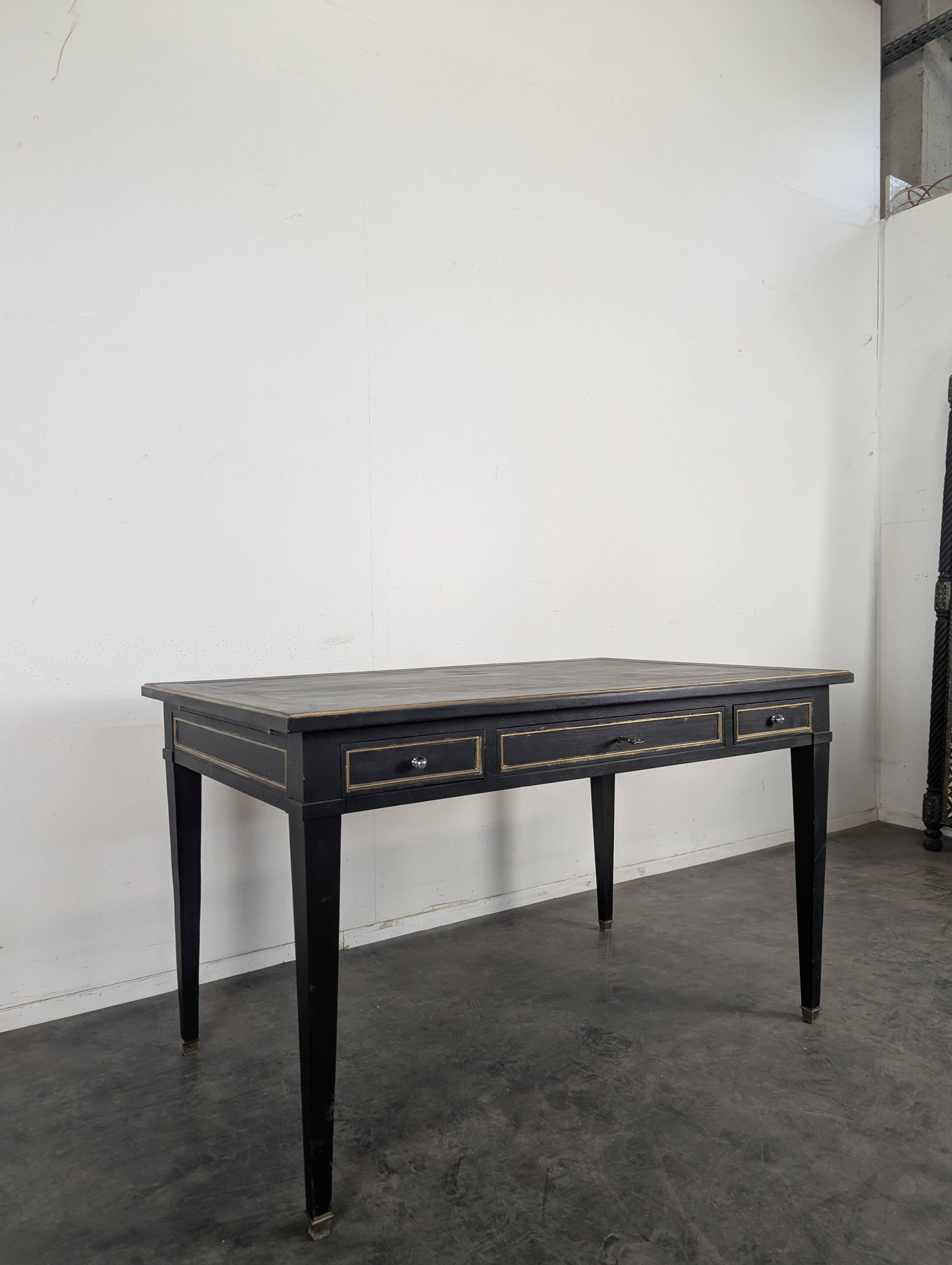Large flat desk in Louis XVI style, black lacquered with gold highlights.
