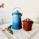 Old vintage milk jug in degraded blue enameled sheet metal