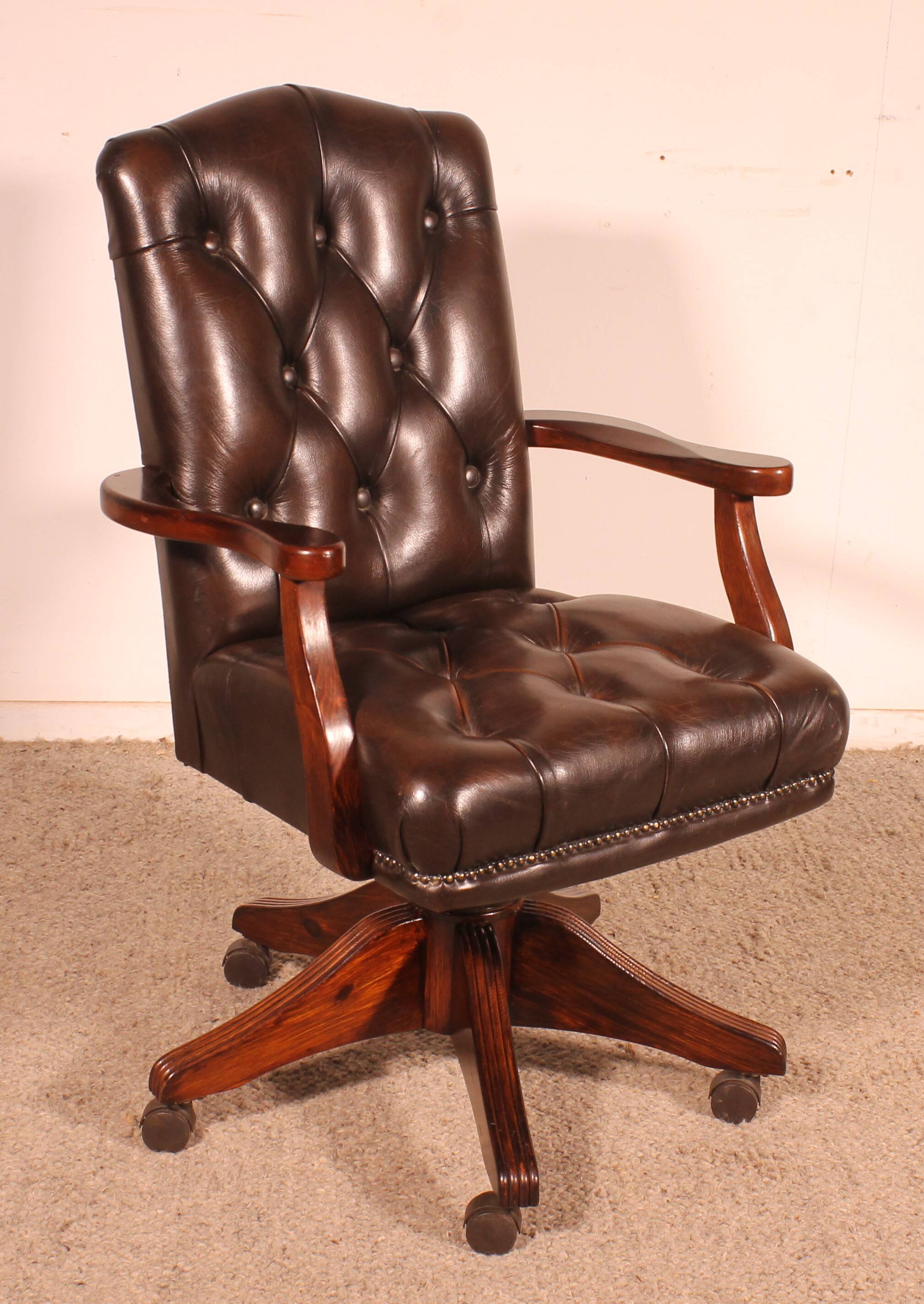 Office chair known as a director's chair in wood and tufted leather.