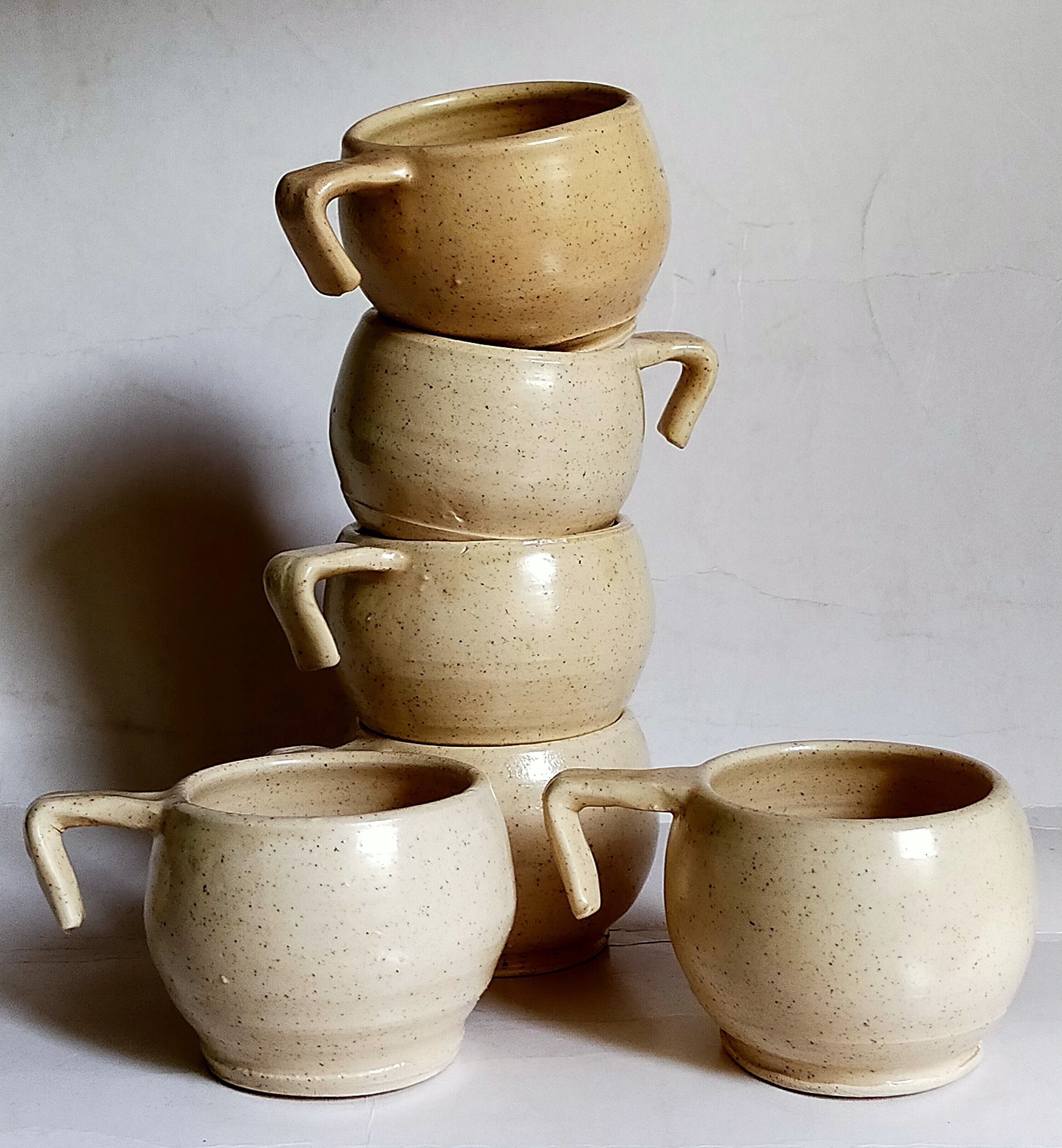 Six vintage potter's ceramic cups with vanilla enamel