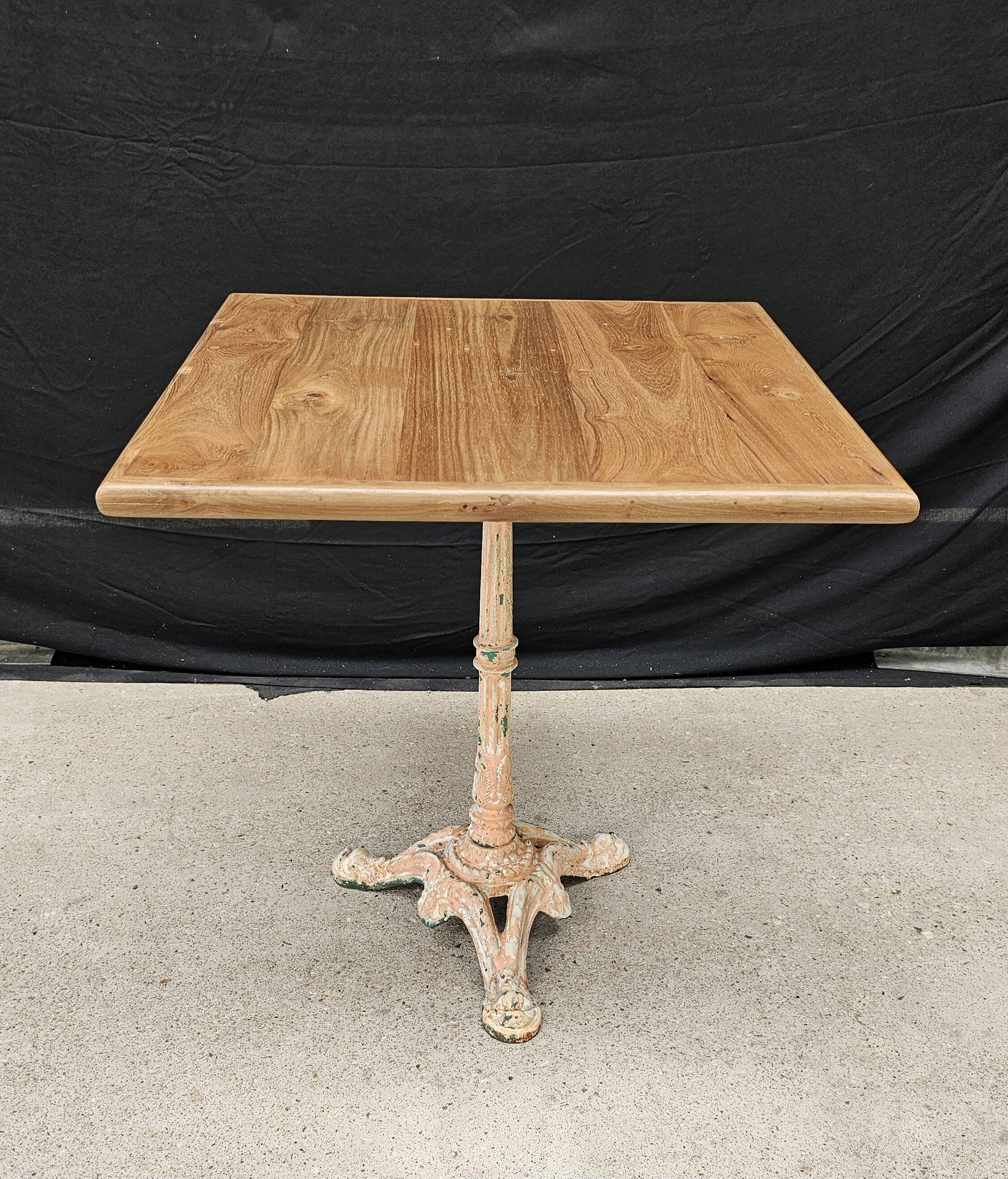 Bistro table with cast iron base and solid teak top