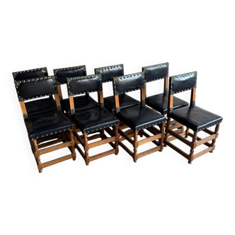 Ensemble de 8 chaises de salle à manger flamandes en chêne foncé et cuir noir, cloutées de laiton, style néo-Renaissance.