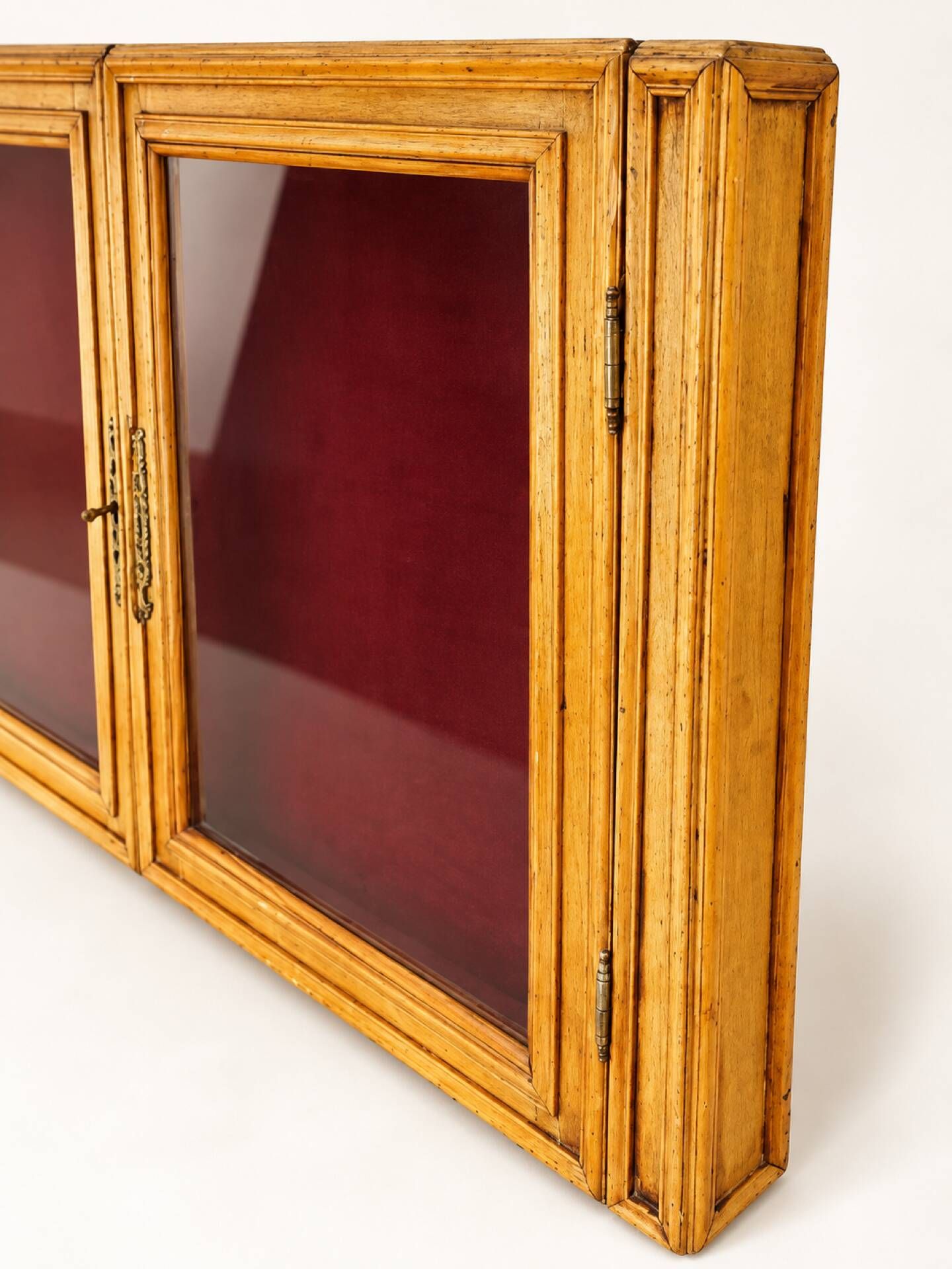 Vintage wall display cabinet in moulded wood and glass – burgundy background