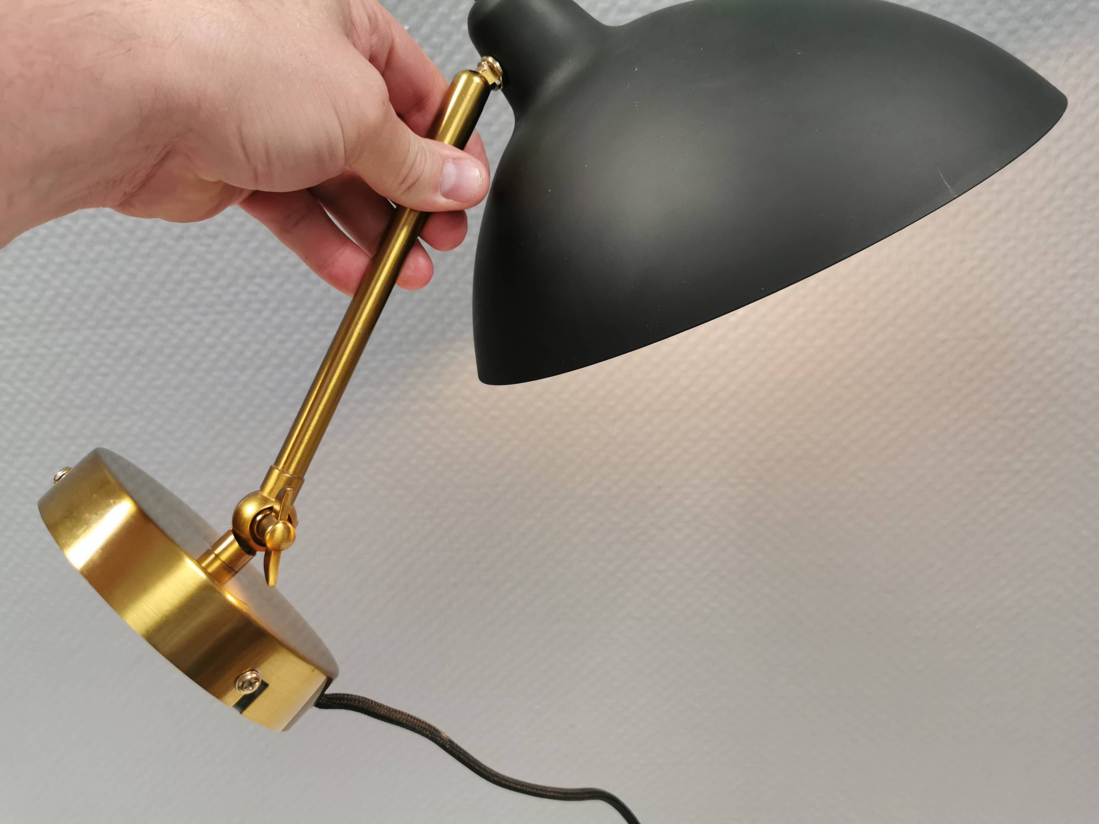 A wall lamp in black and brass-coloured finishes. Danish, early 2000s.