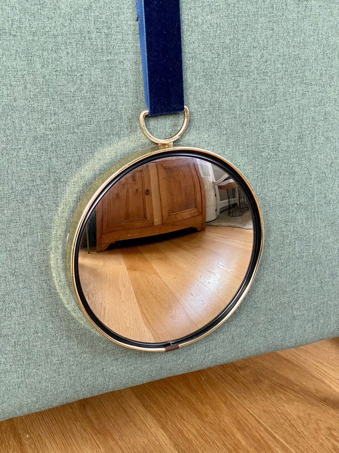 Vintage witch's eye curved mirror hangs velvet ribbon