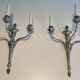 A pair of important Louis XVI style silver-plated wall sconces with three light arms.