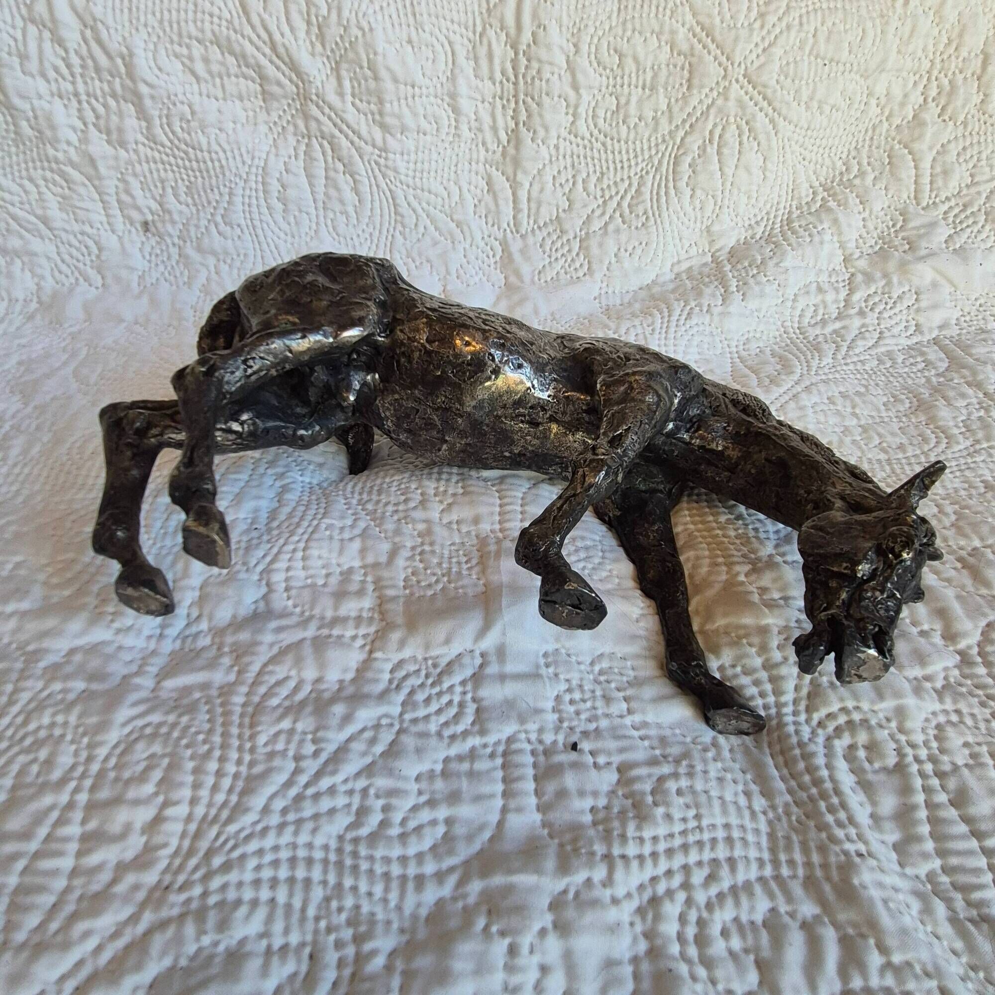 Sculpture of a grazing horse with a silver finish.