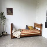 Brutalist style bed with chain and straw