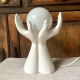 Ceramic table lamp depicting two hands holding a globe, 1980