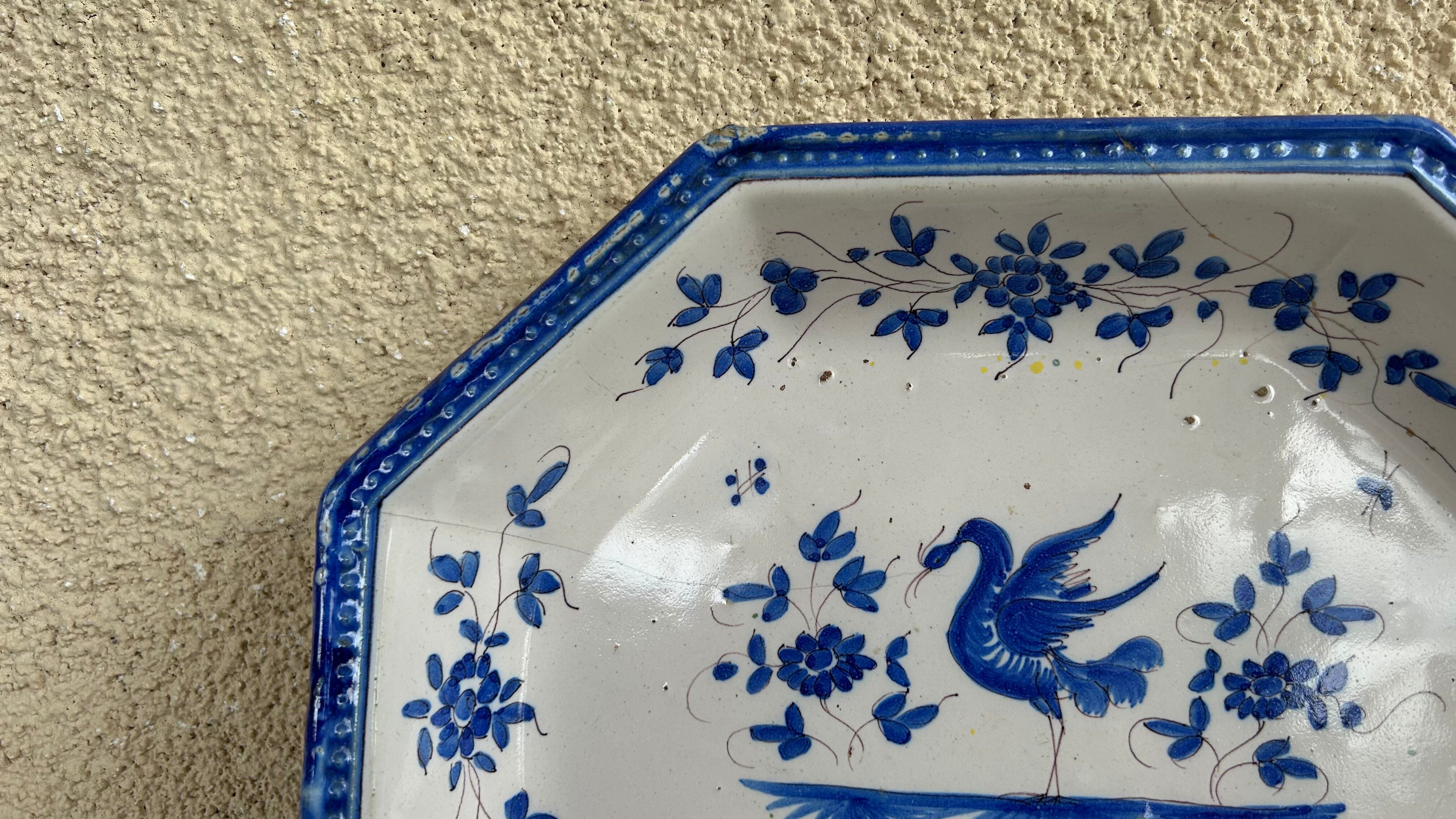 Antique octagonal plate in blue and white pottery with bird decoration.