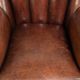 Fauteuil en peau de mouton confortable au design unique, fini avec un passepoil noir.