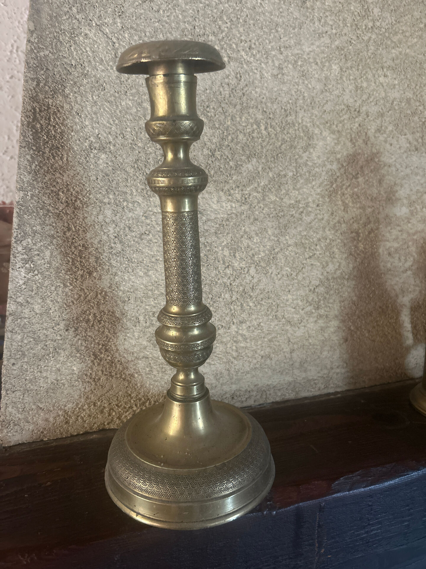 Large antique brass candlestick with floral decoration.