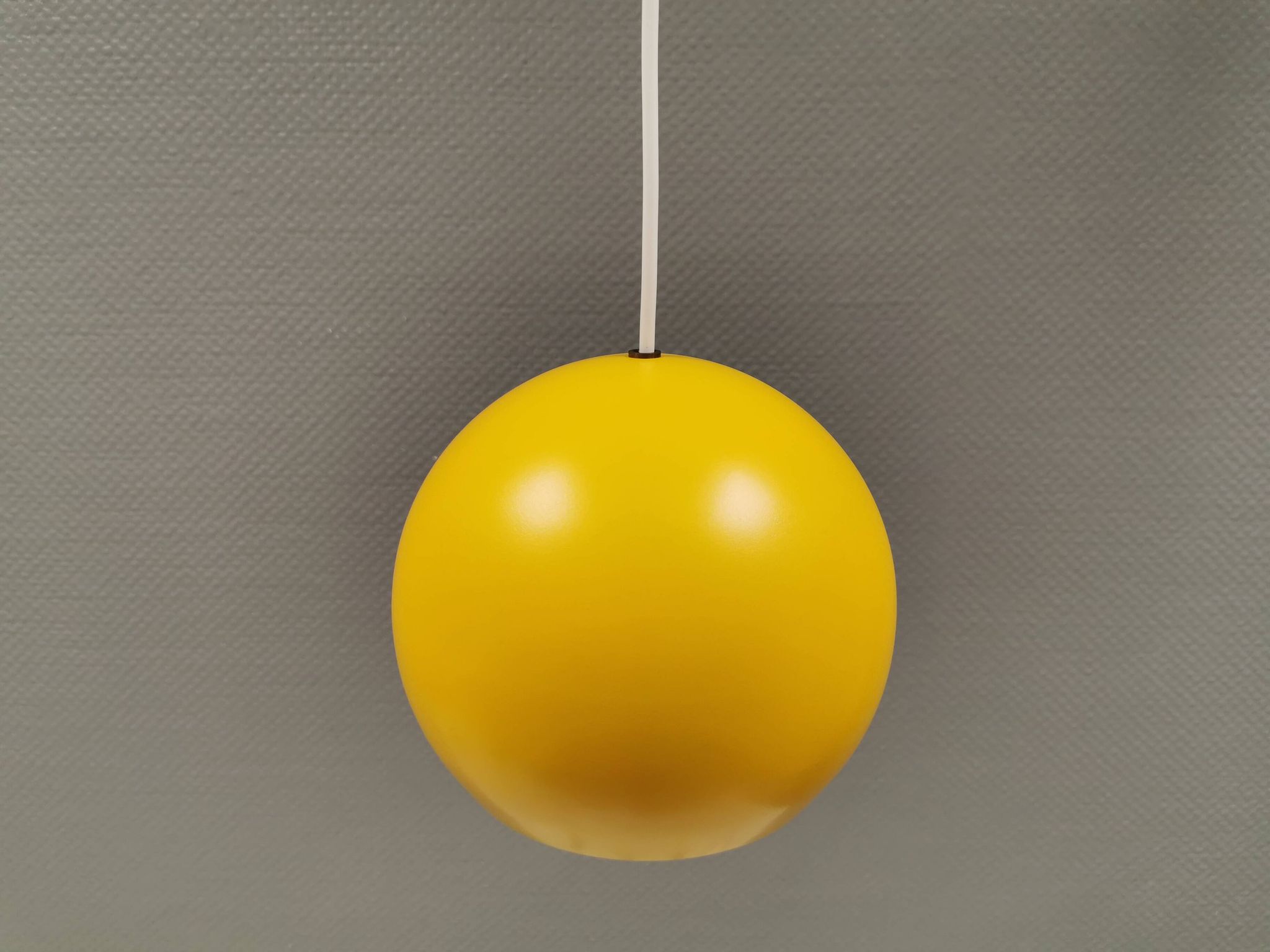 Lampe suspendue sphérique en jaune ensoleillé.
