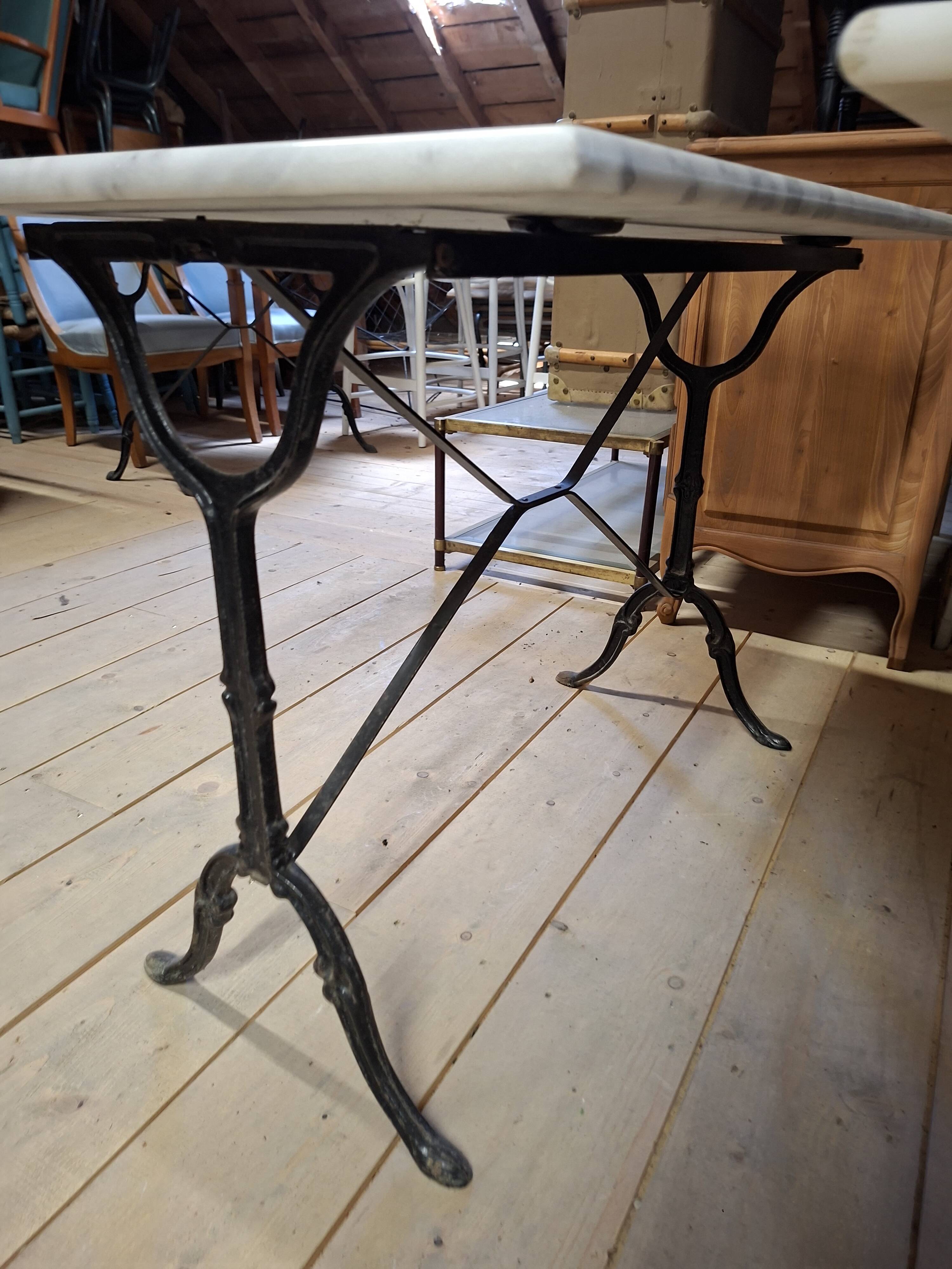 Pair of bistro tables in marble and cast iron.