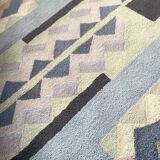 Hand-knotted wool rug by Tisca with a geometric pattern, signed "ILES", France, 1990s.