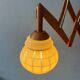 Vintage wall lamp with teak wood scissors and glass shade.