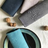Set of four old damasked and monogrammed napkins, dyed in multiple colors