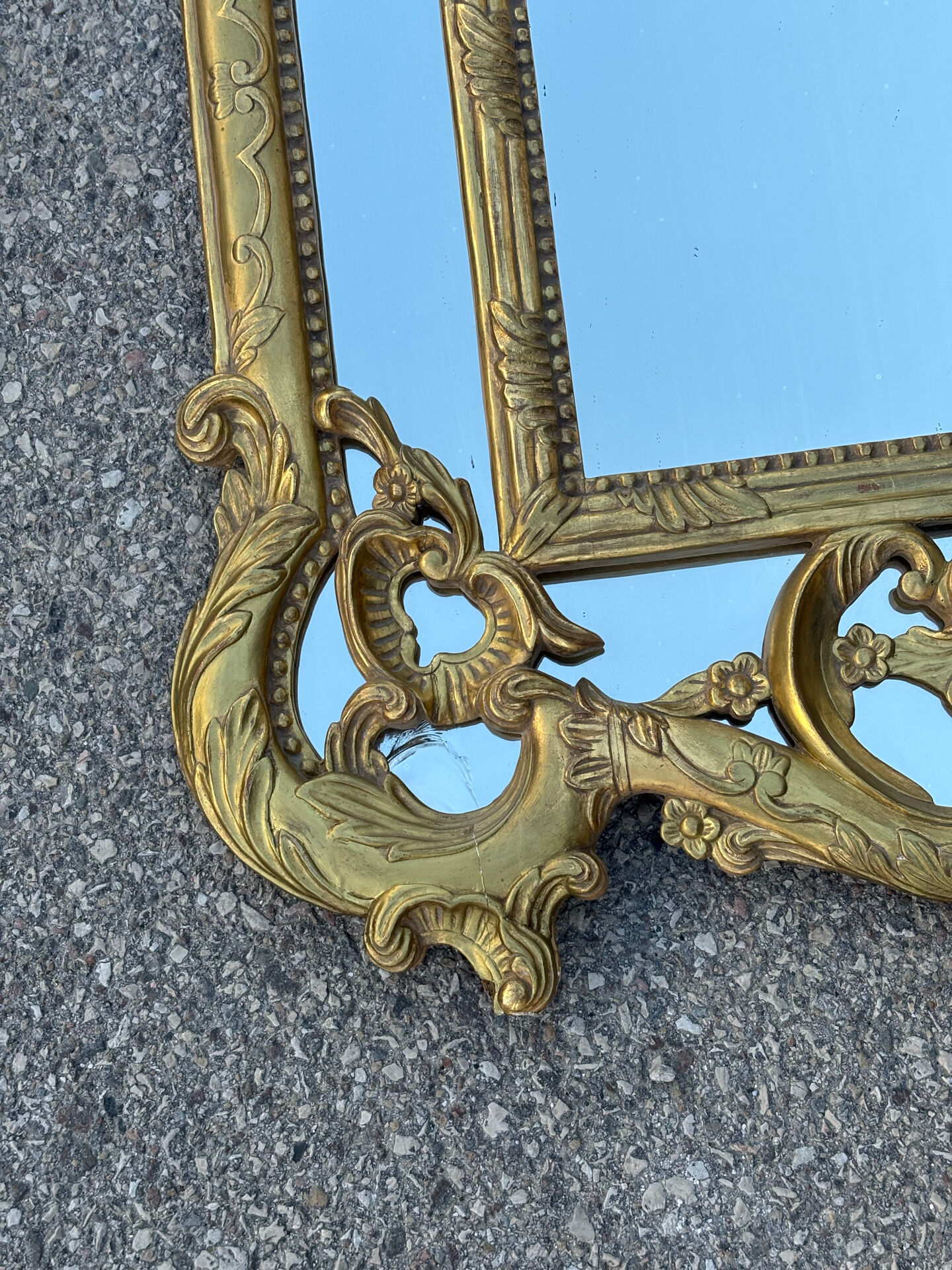 Large mirror with carved and gilded wooden frame, in Regency style.