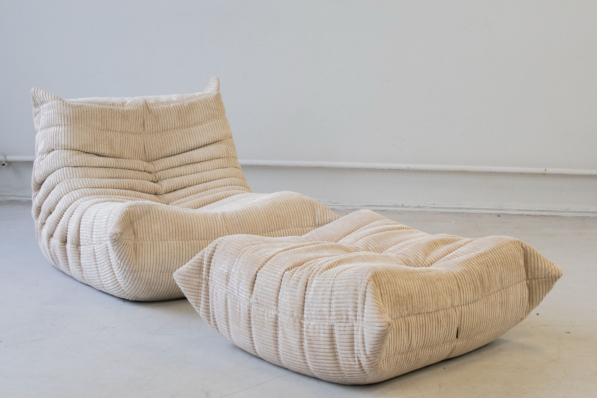 Togo set of 2 armchairs and poufne in beige corduroy