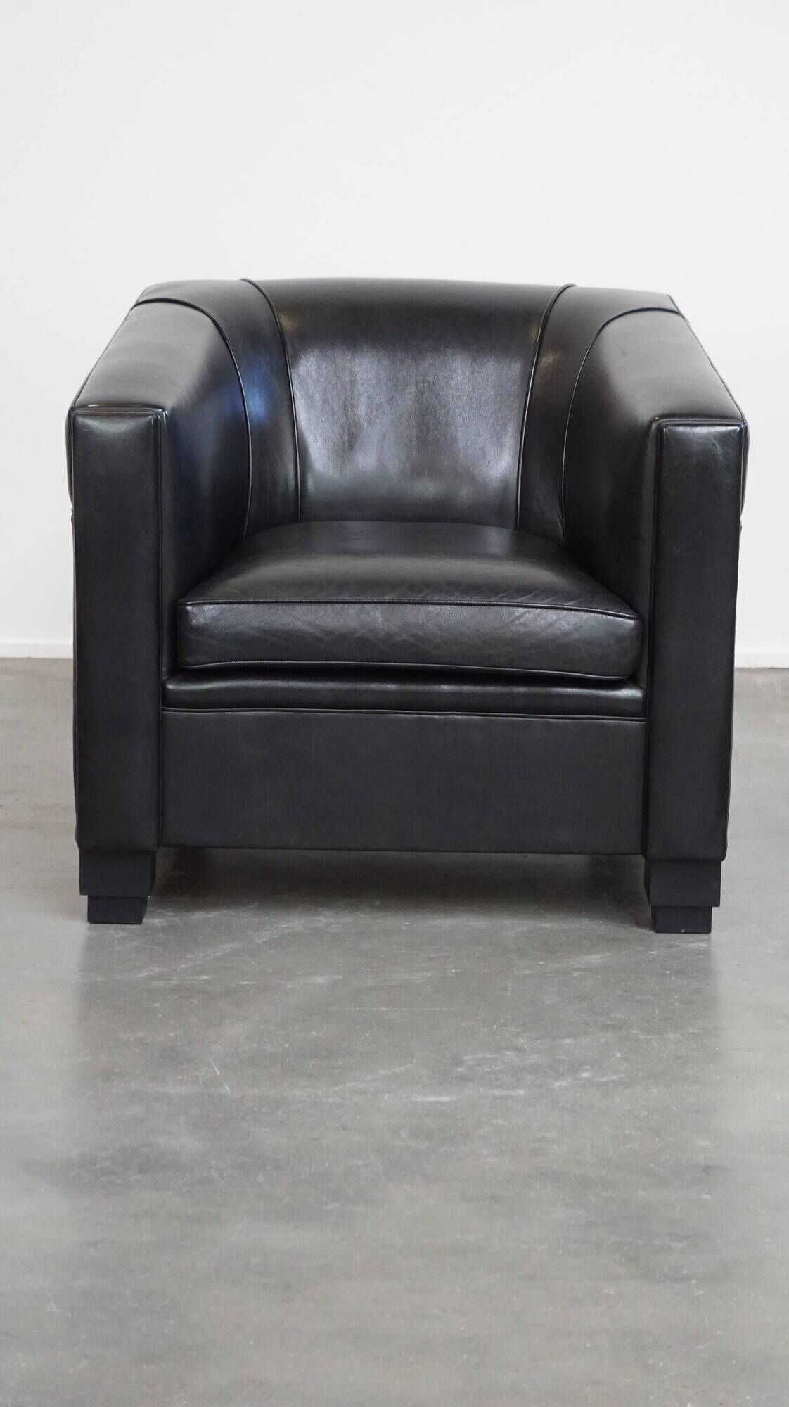 Very comfortable black Art Deco design armchair, made of sheepskin leather