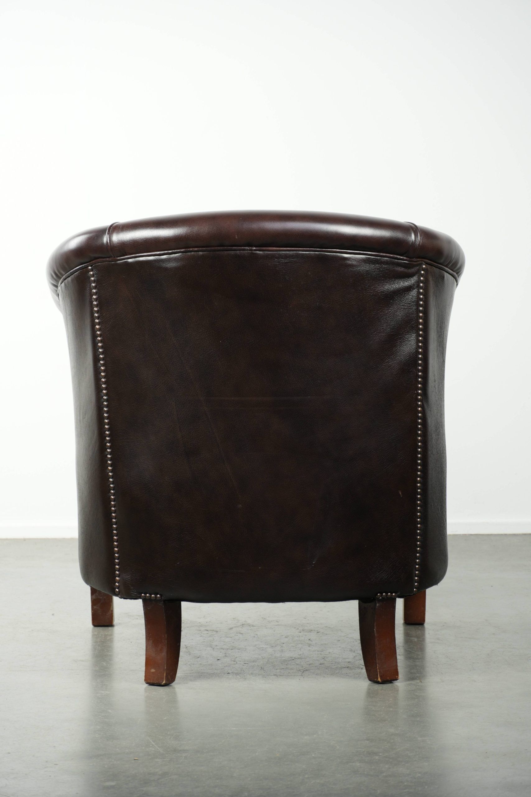 Dark cow leather club armchair with a stylish design in English style