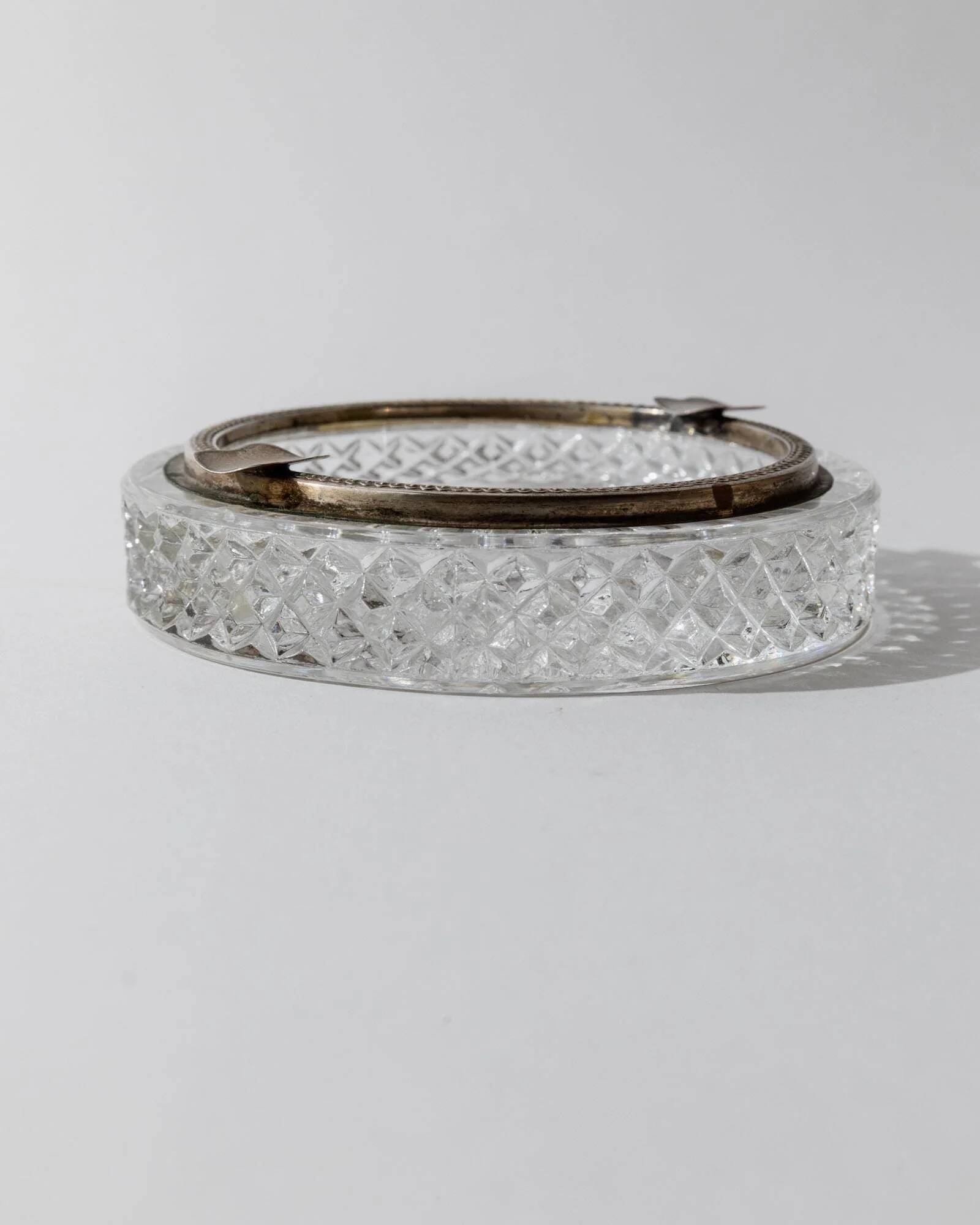 Vintage crystal glass ashtray from the 1920s, silver-edged with a textured pattern, Art Deco table decoration.