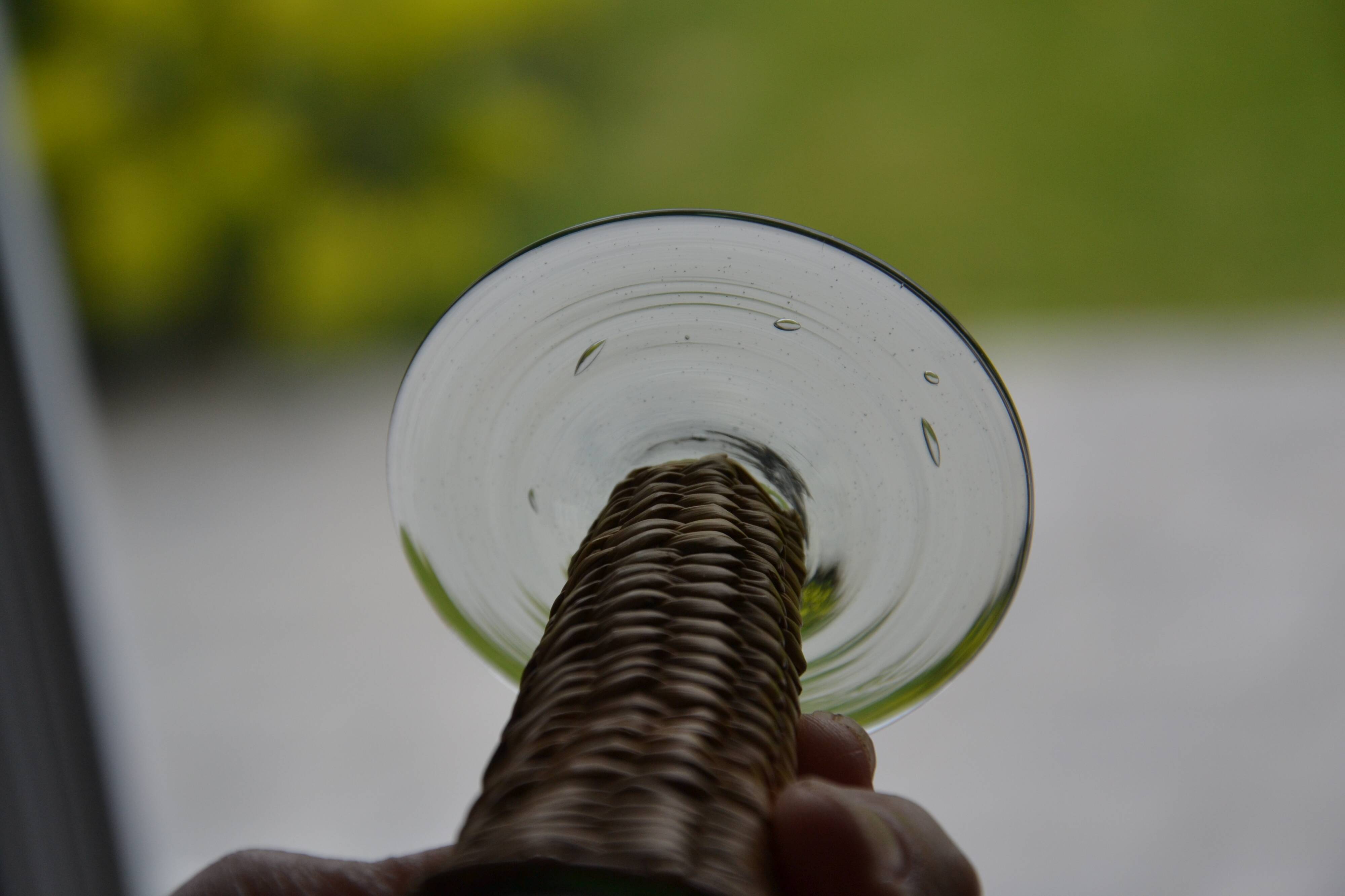 Four stemmed glasses surrounded by rattan.