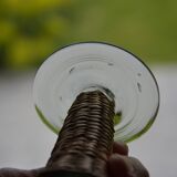 Four stemmed glasses surrounded by rattan.