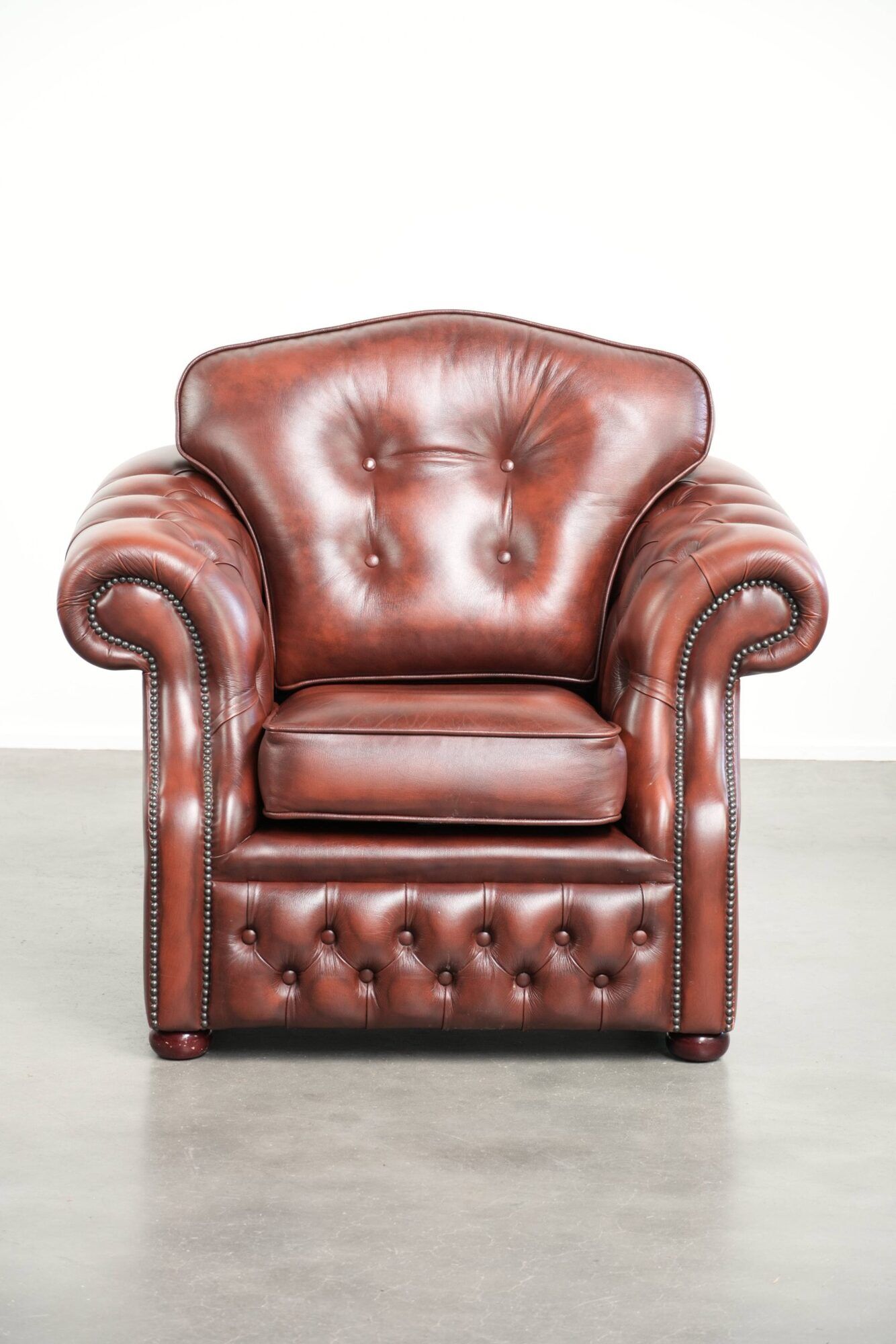 Cowhide chesterfield armchair in a warm brown colour with decorative nails