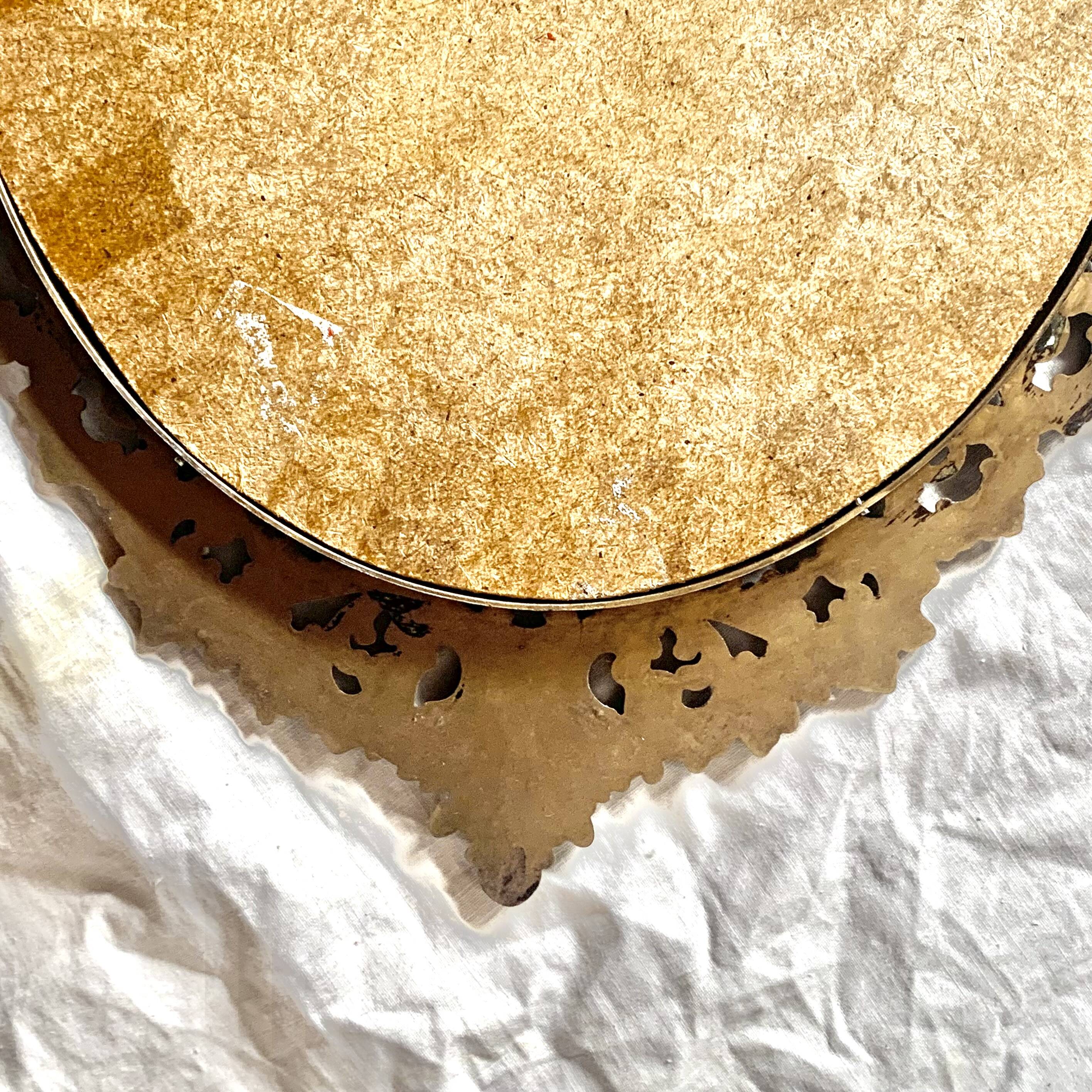 Old oval wall mirror in gilded brass