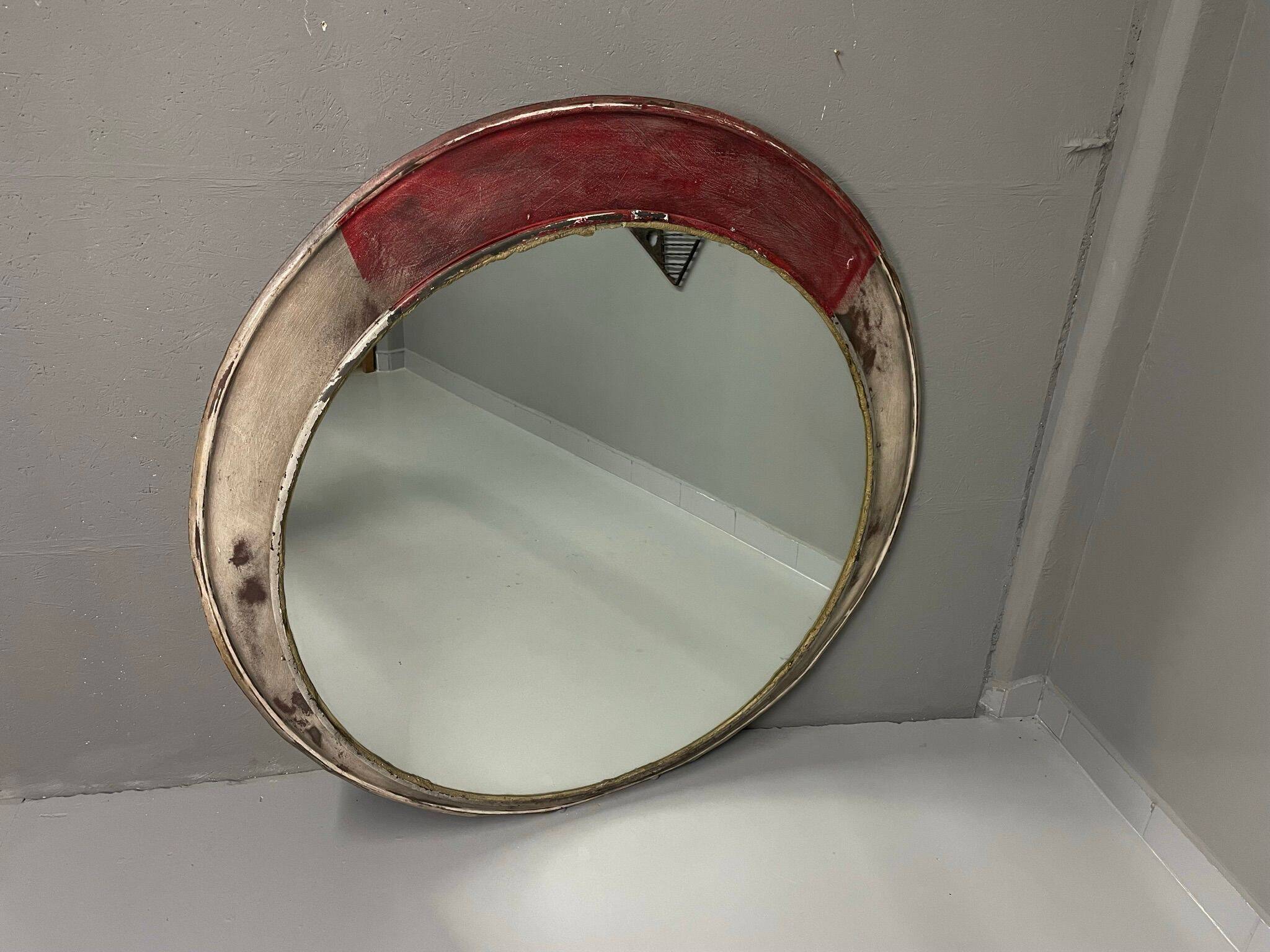 Vintage round mirror with an industrial metal frame in a painted finish.