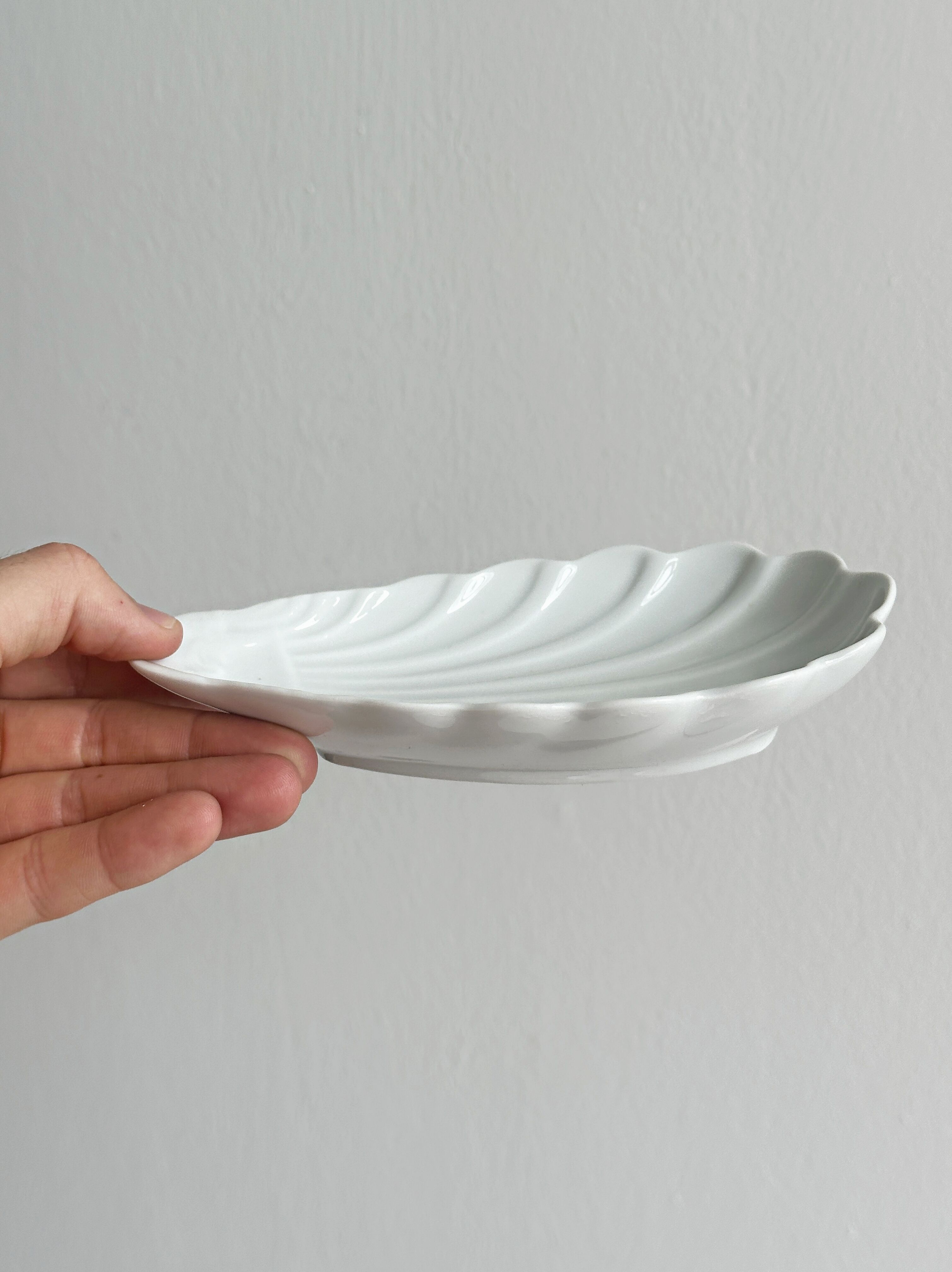 Set of white porcelain ramekins, ribbed shell shape.