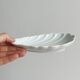 Set of white porcelain ramekins, ribbed shell shape.