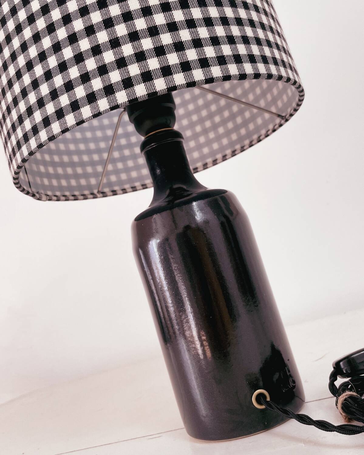 Black earthenware lamp and gingham lampshade