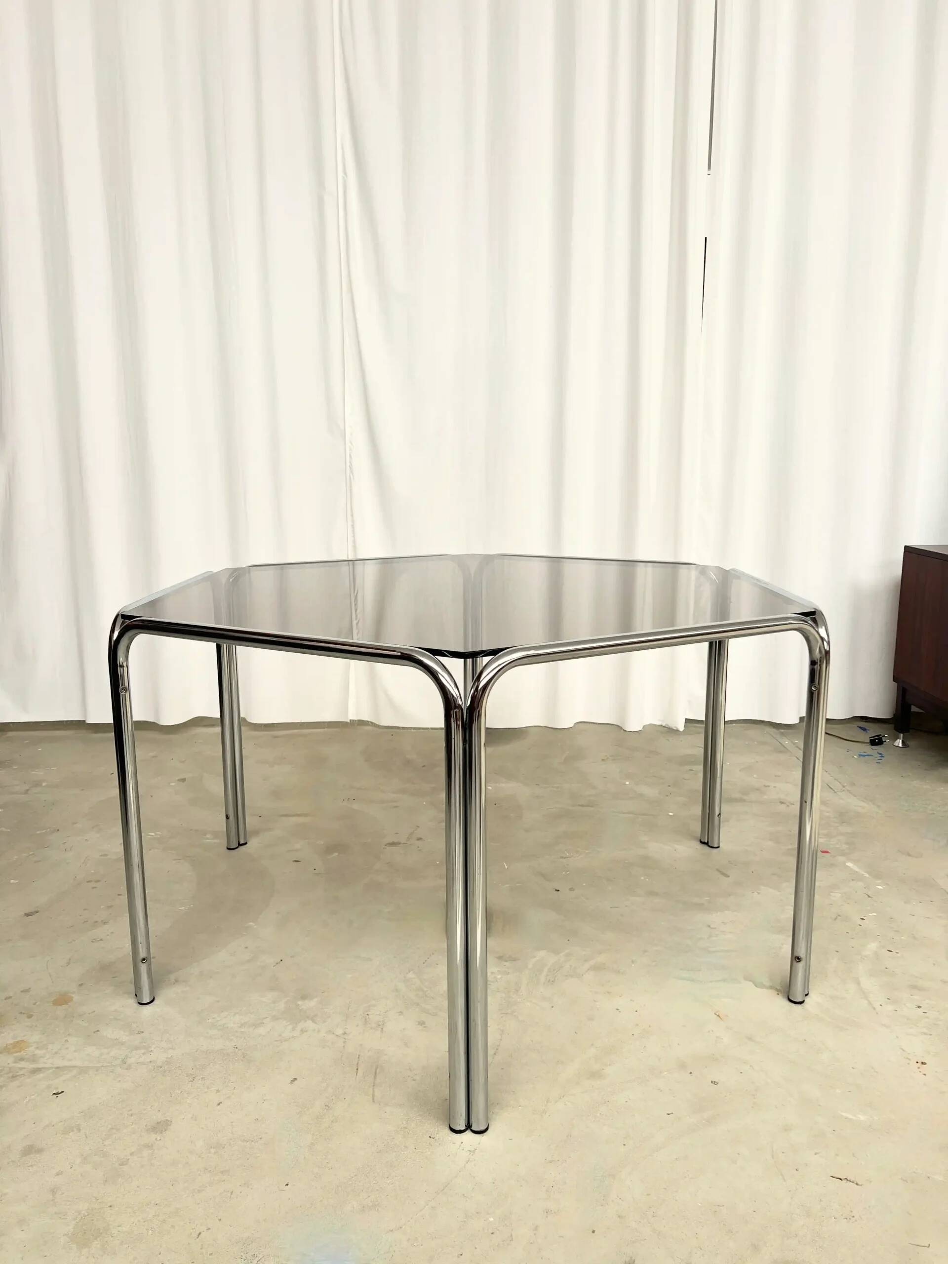 Vintage hexagonal table with smoked glass top and chrome metal structure.