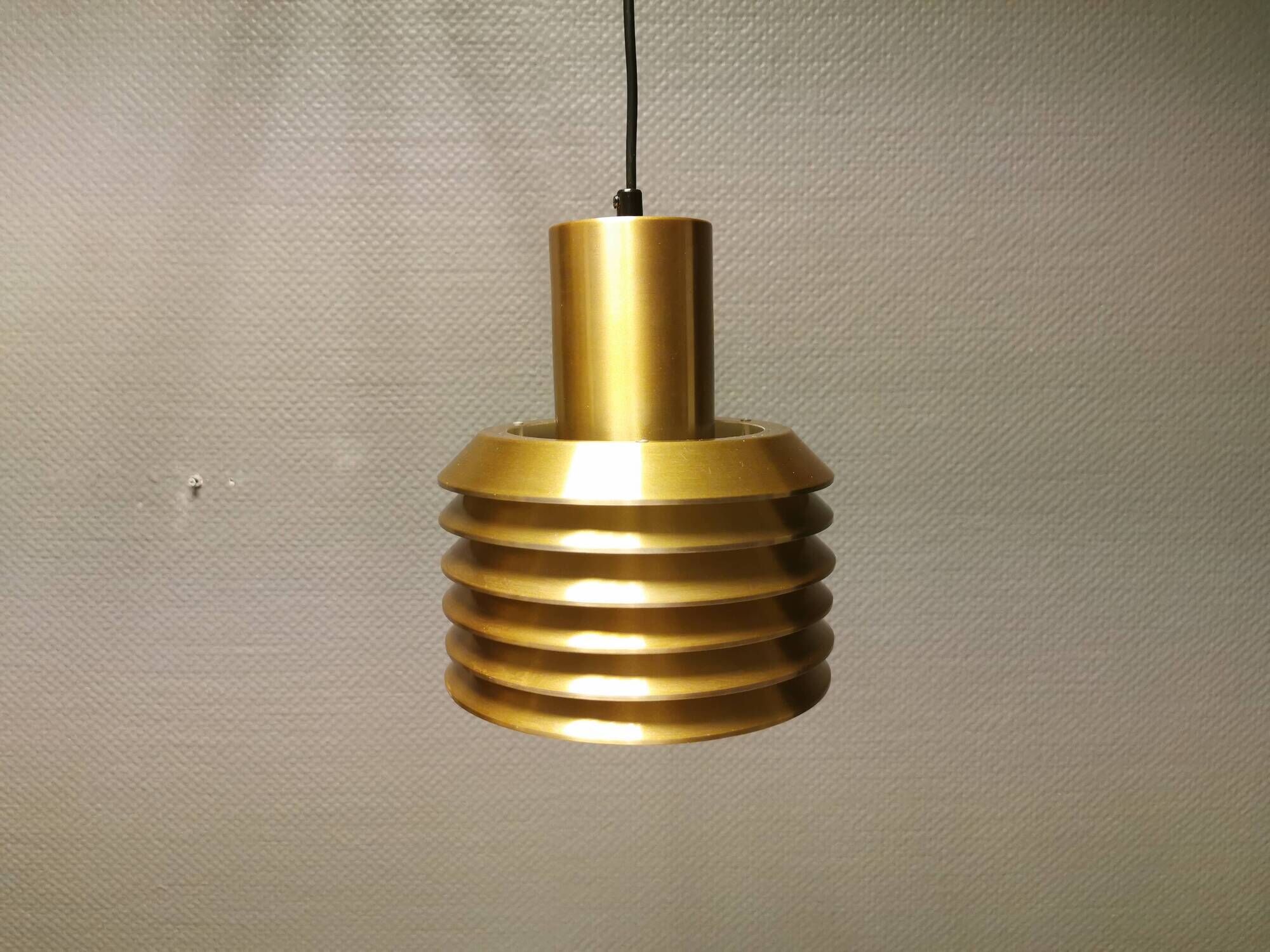 Hanging lamp in gold-colored aluminum with many layers of shades.