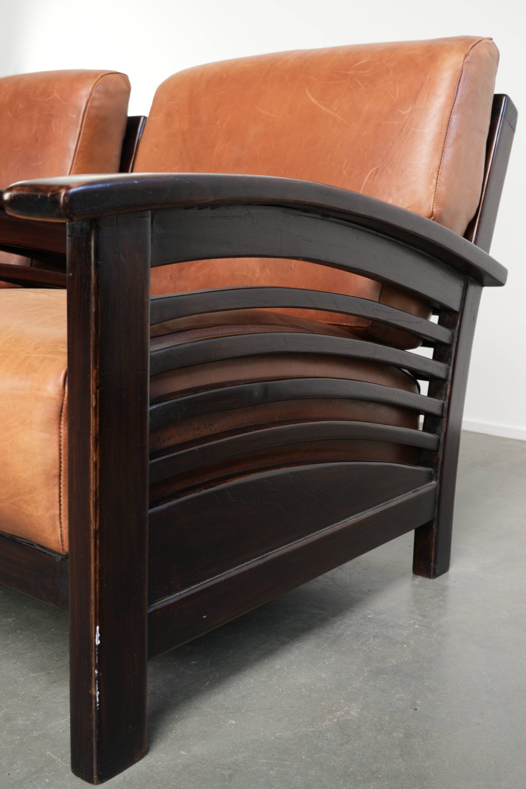 Ensemble de 2 fauteuils Art Déco en cuir de vache couleur cognac du 20e siècle.