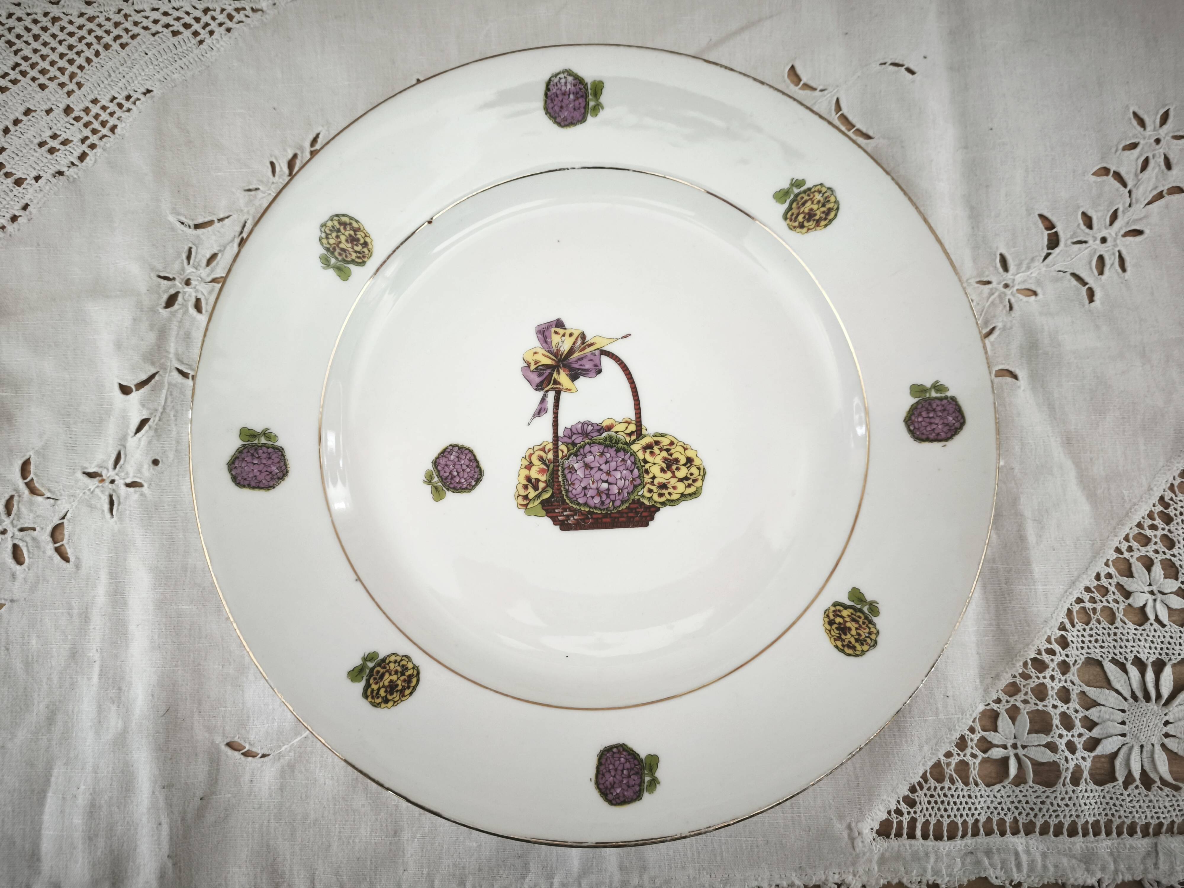 Round porcelain plate from Limoges with a hydrangea basket design.