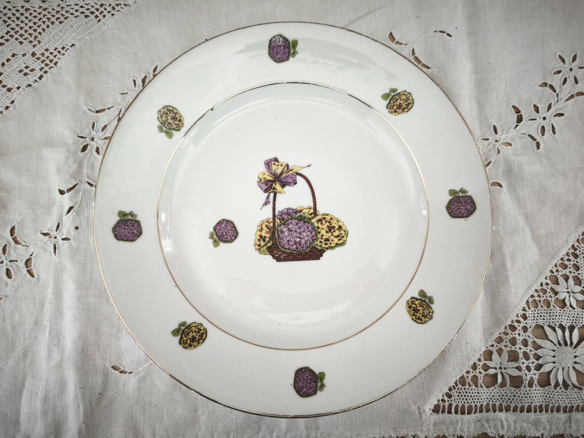 Round porcelain plate from Limoges with a hydrangea basket design.
