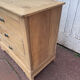 Raw wood chest of drawers with three drawers and shell handles.