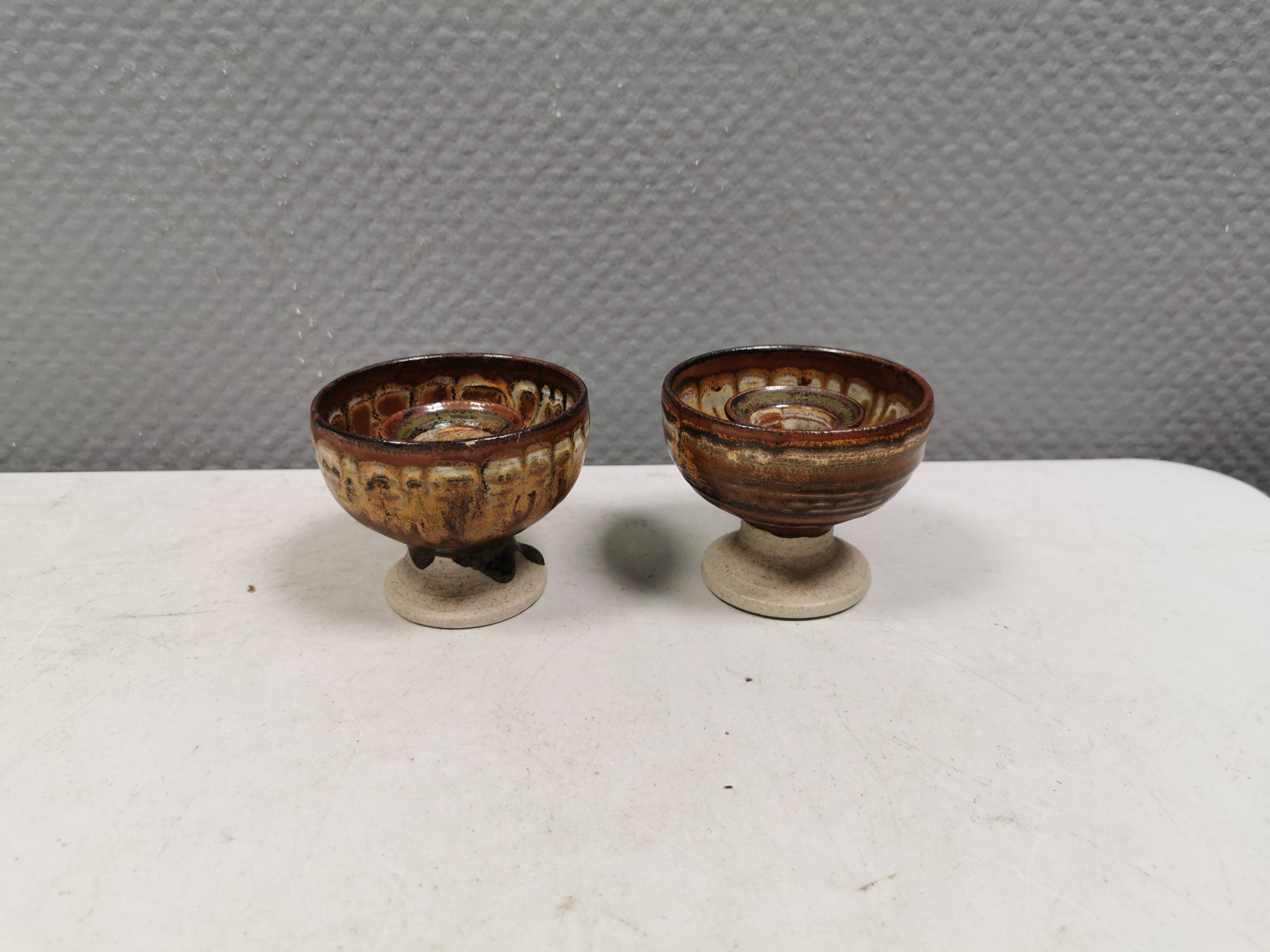 A set of ceramic candle holders in earthy colours.